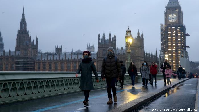 Orang-orang berjalan mengenakan masker di London, Inggris