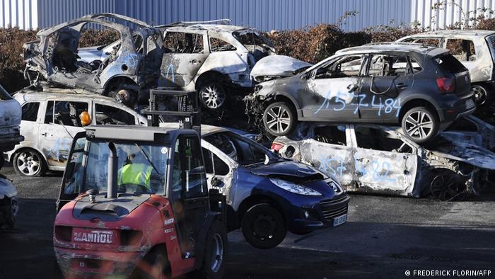 City employees in Strasbourg stack the remains of burned-out cars on January 1, 2022