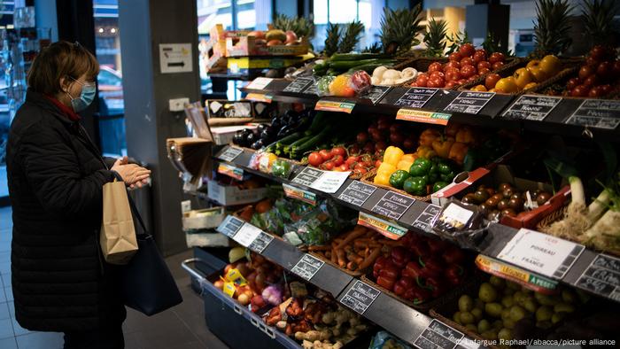 A woman shops for fruit and vegetables in a grocery store