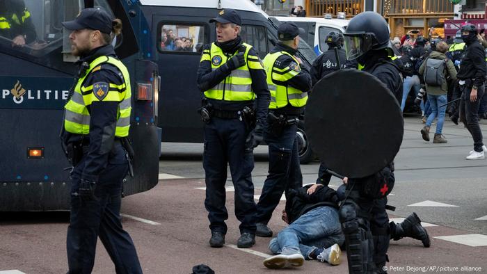 Police hold a demonstrator to the ground in Amsterdam