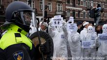 A protestor shows a sign reading Vrijheid or Freedom to a riot police as thousands of people defied a ban to gather and protest the Dutch government's coronavirus lockdown measures, in Amsterdam, Netherlands, Sunday, Jan. 2, 2022. The municipality of the Dutch capital banned the protest, saying police had indications some demonstrators could be attending prepared for violence. (AP Photo/Peter Dejong)