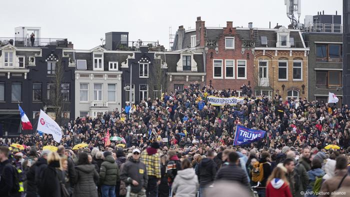 A protester raises a Trump flag at a protest against COVID restrictions in Amsterdam, Netherlands