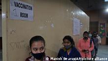 Indian teens wait to receive their vaccination for COVID-19 at a government school, in New Delhi, India, Monday, Jan. 3, 2022. India has begun vaccinating teens in the age group of 15 to 18, as more states are enforcing tighter restrictions to arrest a surge of infections stoked by the omicron variant. On Monday, state governments across the country administered doses at schools, hospitals and through special vaccination sites amid a rapid rise in coronavirus infections, particularly in the country's densely populated cities. (AP Photo/Manish Swarup)