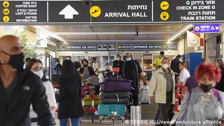 Travelers walk with their luggage outside Ben Gurion International Airport