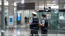 Polizisten stehen im Ankunftsbereich am Flughafen München und warten auf Passagiere, die zuvor mit einer Maschine der Lufthansa aus Kapstadt (Südafrika) angekommen sind. Alle Passagiere aus Südafrika müssen am Flughafen einen PCR-Test machen.