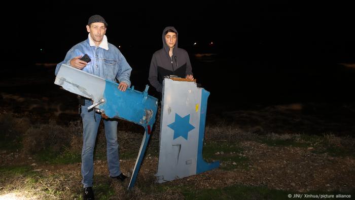 People hold parts of a crashed helicopter in Haifa, Israel, on Jan. 3, 2022.