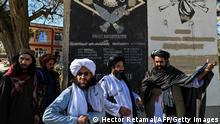 In this picture taken on November 15, 2021, Taliban provincial culture chief Mullah Habibullah Mujahid (R) stands with Taliban members next to a section of a wall of a former US military base with the names of US soldiers in Ghazni. - In the governor's compound of Afghanistan's Ghazni province, a new historical exhibit is unveiled before a rapt audience of Taliban fighters -- sections of blast walls from a former US military base. - To go with 'Afghanistan-US-taliban-history' by Elise Blanchard (Photo by Hector RETAMAL / AFP) / To go with 'Afghanistan-US-taliban-history' by Elise Blanchard (Photo by HECTOR RETAMAL/AFP via Getty Images)