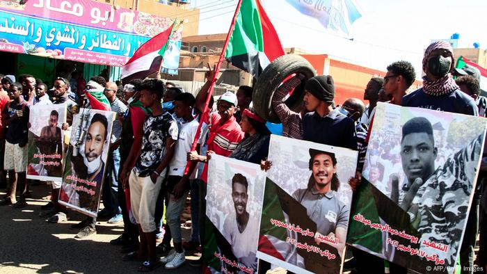 Sudanese demonstrators carry posters of killed protesters in the capital Khartoum against the army's October 25 coup, on December 30, 2021.