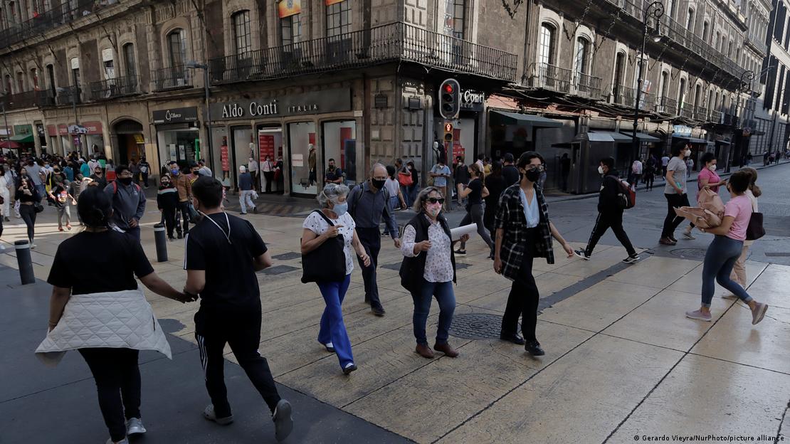Transeuntes de máscara caminham em rua da Cidade do México