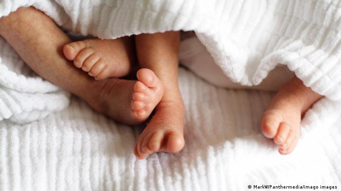 Foto simbólica de dos pares de pies de bebés.
