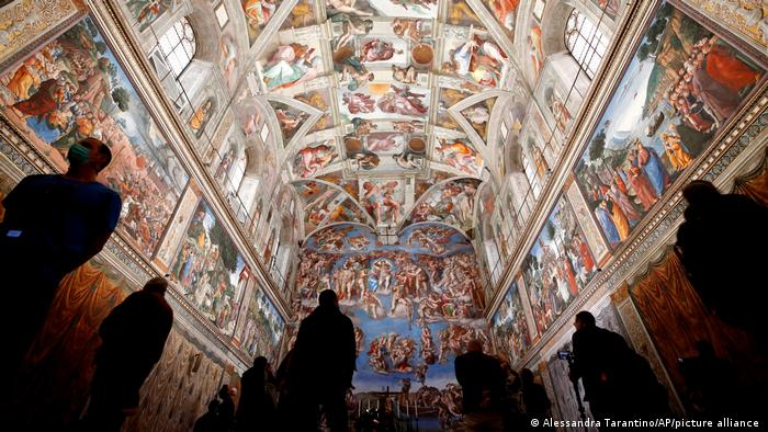 Visitors gaze at the ceiling of the Sistine Chapel with its many frescos.