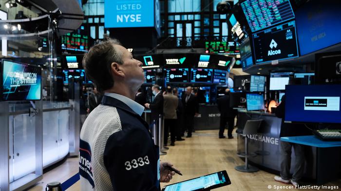 A trader at the New York stock exchange looks up at a screen