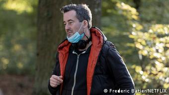 Regisseur Christian Schwochow mit abgesetzten Kopfhörer und abgezogenen Mundschutz.