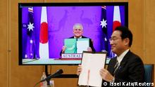 Japan's Prime Minister Fumio Kishida (R) and Australia's Prime Minister Scott Morrison show off signed documents during their video signing ceremony of the bilateral reciprocal access agreement at Kishida's official residence in Tokyo, Japan January 6, 2022. REUTERS/Issei Kato/Pool