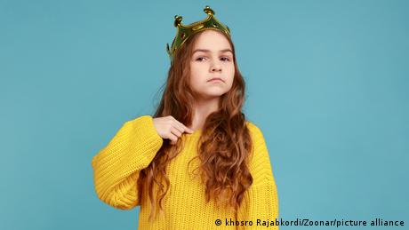 Kleines Mädchen mit gelbem Pullover und Krone