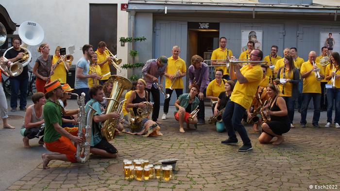 An orchestra in the streets in Esch-sur-Alzette, with people dressed in yellow t-shirts.