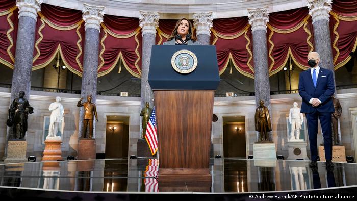President Joe Biden listens as Vice President Kamala Harris speaks from Statuary Hall at the U.S. Capitol 