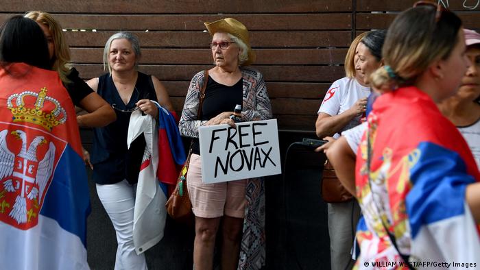 A Novak Djokovic supporter holds a 'Free Novax' banner