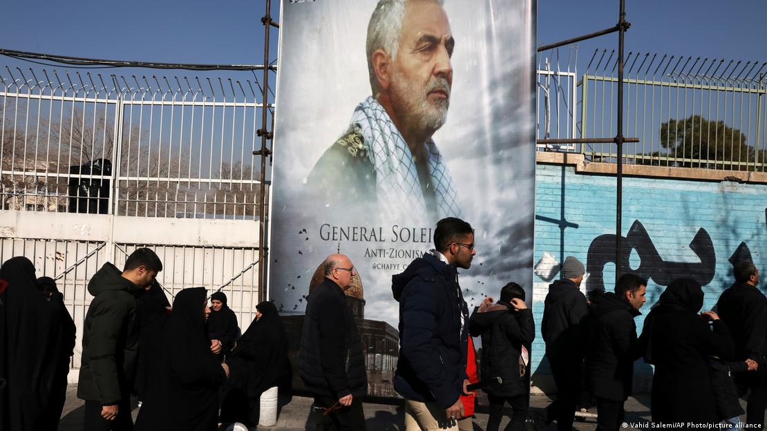 Pessoas caminham em frente a imagem de Qassim Soleimani Pessoas caminham em frente a imagem de Qassim Soleimani
