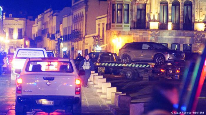 Police work at the scene as they remove a vehicle with bodies left outside the Government Palace in Zacatecas