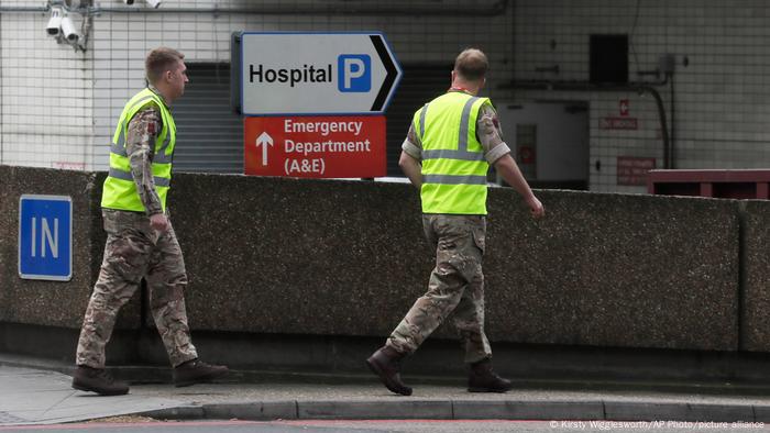 Two British Army soldiers walk into St Thomas' Hospital that is treating some of the coronavirus patients in London in 2020