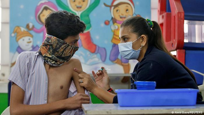 Eine Mitarbeiterin des Gesundheitsamtes verabreicht einem Teenager eine COVID19-Impfung. Ahmedabad, Indien, 03.01.2022.