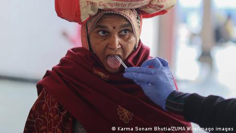 A woman gets a saliva test done to check for COVID-19