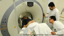 Prof. Osama Sabri (2.v.r) und der Medizinphysiker Dr. Bernhard Sattler bereiten in der Klinik und Poliklinik für Nuklearmedizin des Universitätsklinikums Leipzig eine Untersuchung eines Patienten mit Hilfe von Laserpositionierungssystemen in einem Kombinationsbildgebungssystem PET/CT vor, aufgenommen am 11.02.2009. Eine Kombination von Hirnaufnahmen mit neuentwickelten Systemen ermöglichen eine neuartige Diagnostik, die im Rahmen einer internationalen Studie unter Leitung von Prof. Osama Sabri mit Wissenschaftlern in Frankreich, den USA und Schweden durchgeführt wird. So können mit einem radioaktiven Markerstoff bei der Bildgebung möglicherweise die Vorboten für eine später einsetzende Erkrankung an Alzheimer nachgewiesen werden. Foto: Waltraud Grubitzsch +++(c) dpa - Report+++