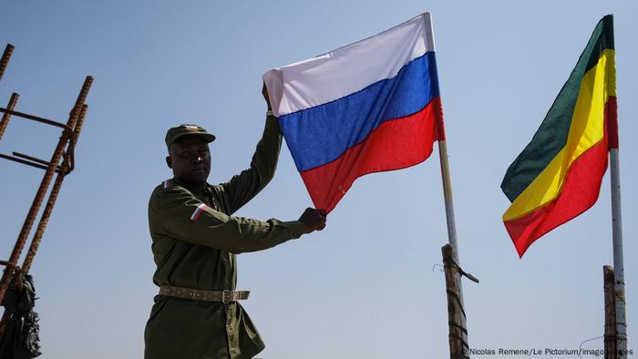 Malian soldier holds a Russian flag.