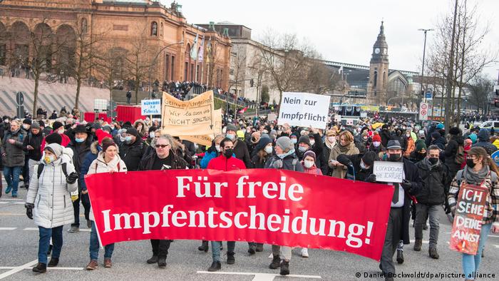 Protesters in a demonstration against COVID restrictions in Hamburg with a banner that reads, For free vaccination decisions!