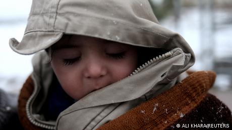 Baby Sohail Ahmadi, bundled up in a scarf and beige coat with hood