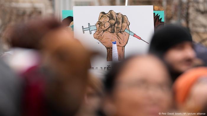 People hold up a banner as they gather to protest against the governments restrictions to curb the spread of COVID-19 in Prague, Czech Republic