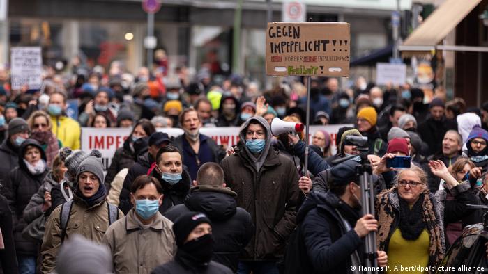 Demonstrators hold up signs against compulsory vaccinations during a protest in Frankfurt, Germany