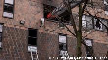 Ladders are seen erected beside the apartment building in the Bronx after a fire occurred on Sunday, Jan. 9, 2022, in New York. (AP Photo/Yuki Iwamura)
