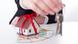 A woman holds the keys to a property above a model of her new home and a sheaf of euro notes A woman holds the keys to a property above a model of her new home and a sheaf of euro notes