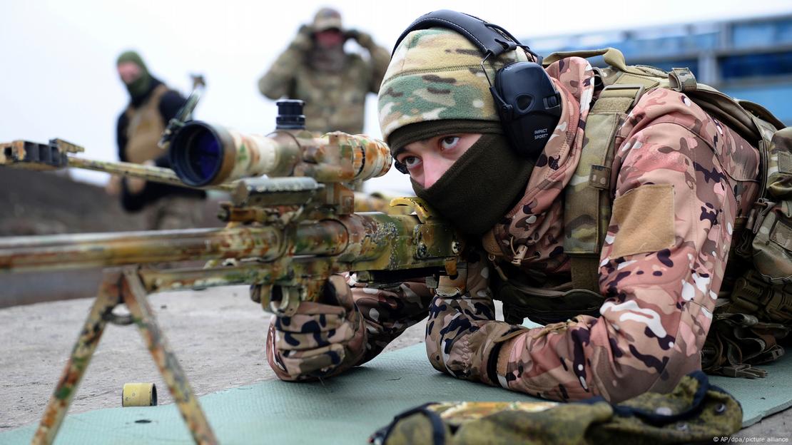 Soldado com roupa de camuflagem em exercício de tiro