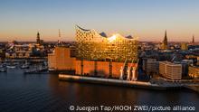 a large waterfront building reflects the sun 