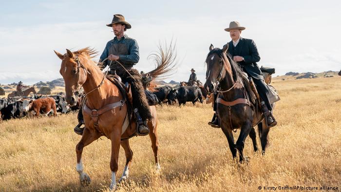 A still from The Power of the Dog Netflix with two men on horses. 