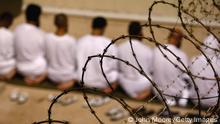 GUANTANAMO BAY, CUBA - OCTOBER 28: (EDITORS NOTE: Image has been reviewed by U.S. Military prior to transmission) A group of detainees kneels during an early morning Islamic prayer in their camp at the U.S. military prison for enemy combatants on October 28, 2009 in Guantanamo Bay, Cuba. Although U.S. President Barack Obama pledged in his first executive order last January to close the infamous prison within a year's time, the government has been struggling to try the accused terrorists and to transfer them out ahead of the deadline. Military officials at the prison point to improved living standards and state of the art medical treatment available to detainees, but the facility's international reputation remains tied to the enhanced interrogation techniques such as waterboarding employed under the Bush administration. (Photo by John Moore/Getty Images)