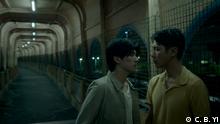 Filmstill Moneyboys: Zwei junge Männer stehen in einem Tunnel und schauen sich an 