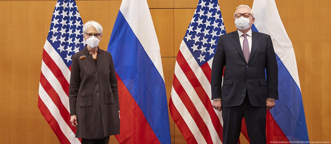 Representantes dos EUA, Wendy Sherman, e da Rússia, Sergey Ryabkov, posam para foto diante de bandeiras dos dois países
