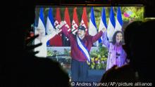 Neighbors watch the inauguration of President Daniel Ortega, on a giant screen at a park in the Julio Buitrago neighborhood of Managua, Nicaragua, Monday, January 10, 2022. Ortega was elected to a fourth consecutive term in Nov. 7 elections that were broadly criticized as a farce after seven likely challengers to Ortega were arrested and jailed in the months prior to the vote. (AP Photo/Andres Nunez)