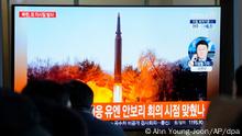 11.01.2022, Südkorea, Seoul: Während einer Nachrichtensendung im Bahnhof von Seoul in Seoul, Südkorea, schauen Menschen auf einen Fernseher, der ein Archivbild eines nordkoreanischen Raketenstarts zeigt. Nordkorea hat nach Angaben des südkoreanischen Militärs erneut eine Rakete in Richtung offenes Meer abgefeuert. Bei dem Geschoss handele es sich möglicherweise um eine ballistische Rakete, teilte der Generalstab in Seoul am Dienstag mit. Die Rakete sei nach dem Start im Landesinneren in Richtung Japanisches Meer (koreanisch: Ostmeer) geflogen. Die koreanischen Buchstaben lauten: «Sitzung des UN-Sicherheitsrats» Foto: Ahn Young-Joon/AP/dpa +++ dpa-Bildfunk +++