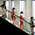 Mujeres con kimono y máscaras protectoras bajan sobre una escalera mecánica.