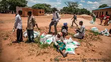 A group of people chats after receiving food donated by the World Food Programme (WFP) and World Vision in Simumbwe on January 22, 2020. - Funding is desperately needed to meet the needs of the 2.3 million severely food insecure people in Zambia. (Photo by Guillem Sartorio / AFP) (Photo by GUILLEM SARTORIO/AFP via Getty Images)