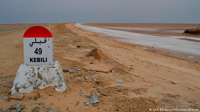A road marker on a highway passing through a massive salt lake in southern Tunisia. 
