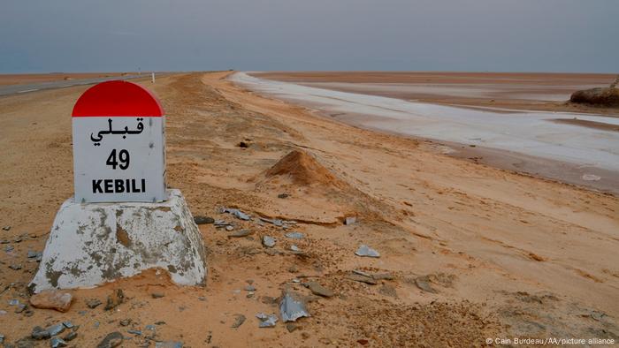 A road marker on a highway passing through a massive salt lake in southern Tunisia. 