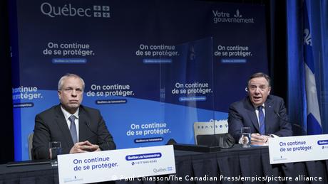 Quebec premier Francois Legault and Quebec director of public health Luc Boileau at a news conference in Montreal. Behind them is the French slogan on continue de se proteger (we're continuing to protect ourselves).