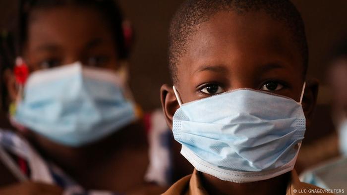 A schoolchild in Ivory Coast wears a blue medical mask