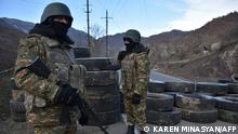 Armenian soldiers stand guard at a checkpoint on the road leading to Kalbajar, near the village of Charektar on November 25, 2020, as Azerbaijan said its forces had entered the Kalbajar district, the second of three to be handed back by Armenia as part of a deal that ended weeks of fighting over Nagorno-Karabakh. (Photo by Karen MINASYAN / AFP)